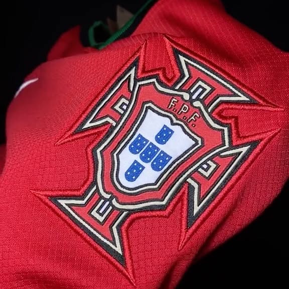 Detalhe do escudo bordado em uma camisa vermelha